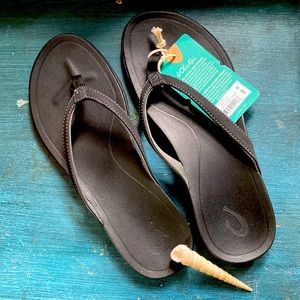 Unworn, black Ho’Opio style Olukai flips flops